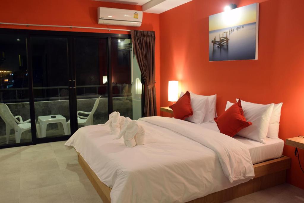 een slaapkamer met een groot bed met oranje muren bij At Home Khaolak in Khao Lak
