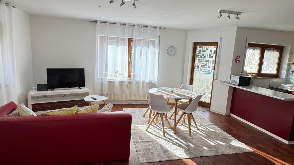 a living room with a red couch and a table at Smart Stay Apartment in Balingen in Balingen