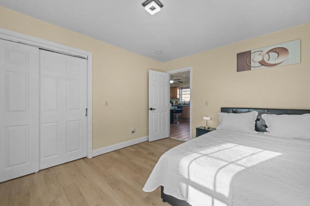a white bedroom with a bed and a door at The Public Street Residence in Providence