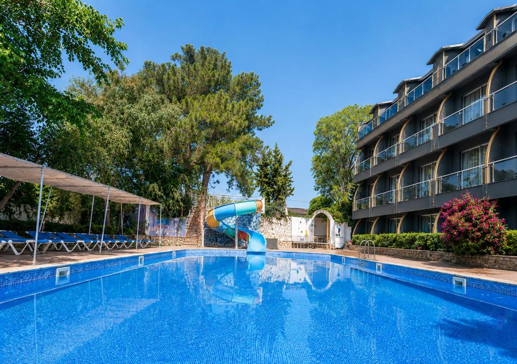 ein Schwimmbad mit Rutsche vor einem Hotel in der Unterkunft Aperion Beach Hotel Side in Manavgat