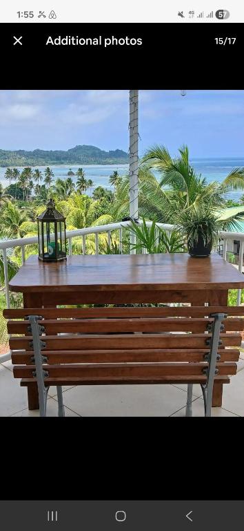 a wooden bench with a table and a light on it at Sunrise Home in Savusavu
