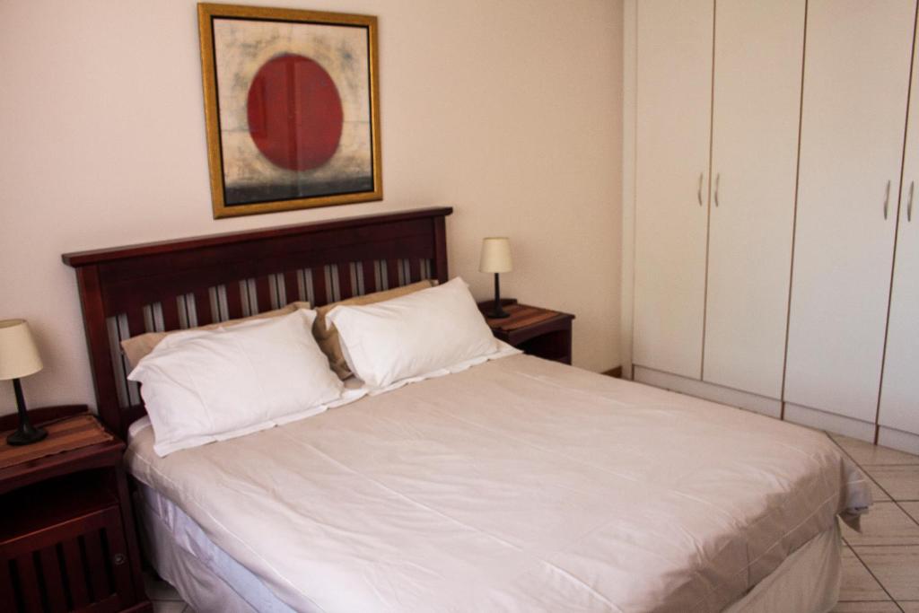 ein Schlafzimmer mit einem großen weißen Bett mit zwei Lampen in der Unterkunft Apartment at 34 Columbine Avenue in Johannesburg