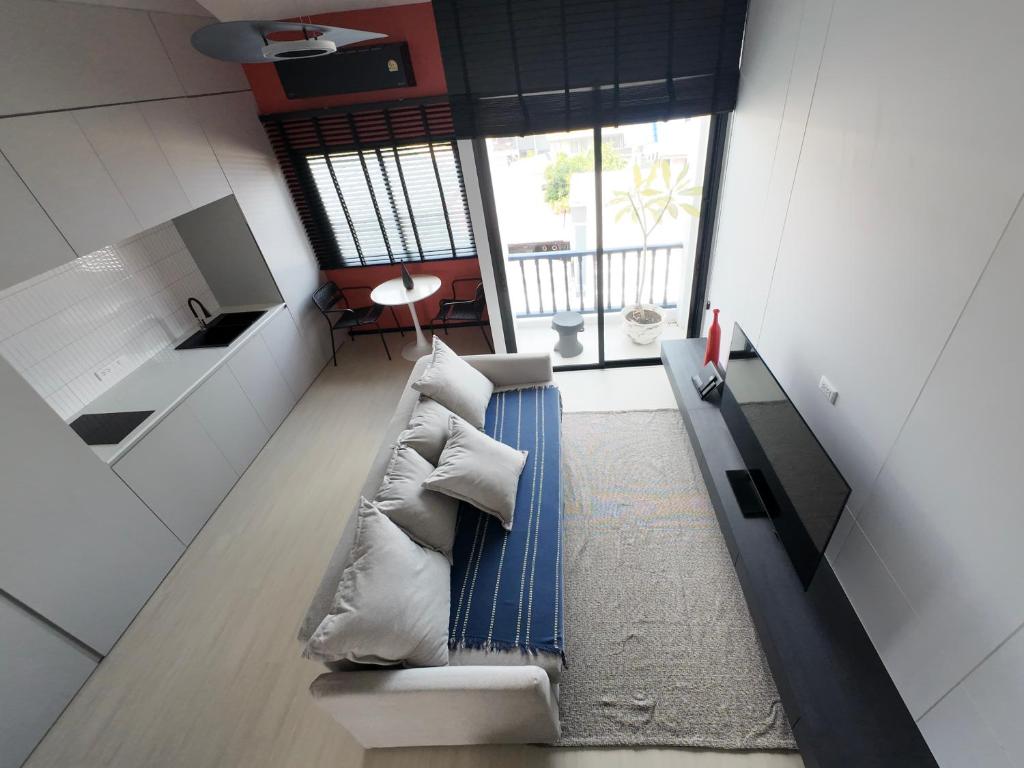 a living room with a couch and a kitchen at TERREST MAISON On Nut in Bangkok