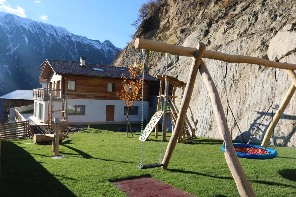 um parque infantil com baloiços em frente a uma montanha em Innerunterstellhof em Naturno