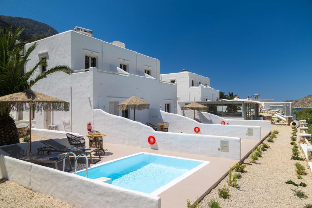 a villa with a swimming pool and a slide at Lithos Suites Sifnos in Kamares