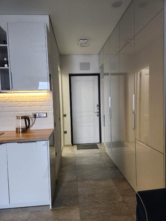 a kitchen with a white door and a hallway at Batumi View apartment in Kachretʼi