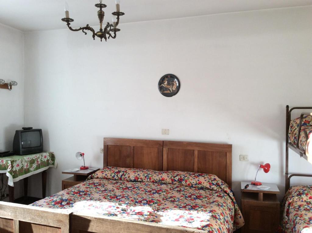 1 dormitorio con 1 cama y reloj en la pared en Albergo Cervo, en Ponte di Legno