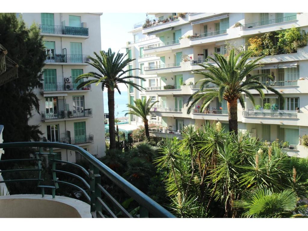 a large building with palm trees and palm trees at Nice Beach - Promenade Des Anglais in Nice