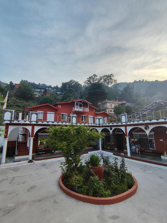 a view of a building with a tree in a courtyard at Prarambh Cottages in Bhowāli