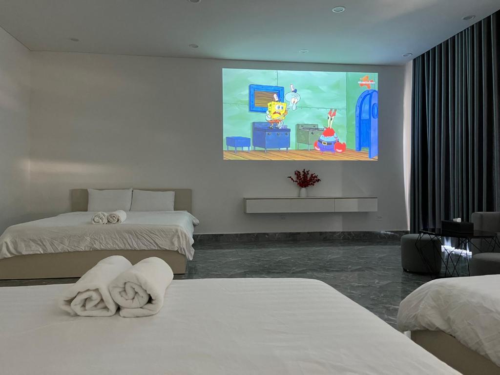 a hotel room with two beds and a video game on the wall at Arcadia homestay in Phú Quốc