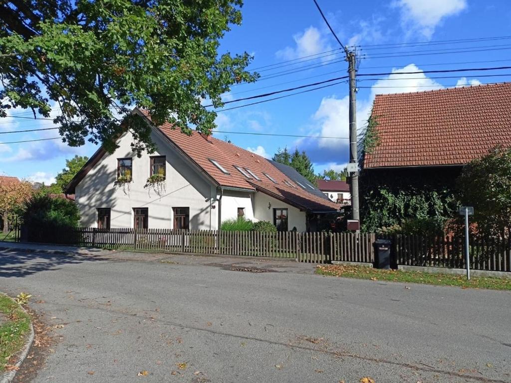 a white house with a brown roof and a fence at Tourist apartment Vysočina BIKE plus FUN in Nové Město na Moravě