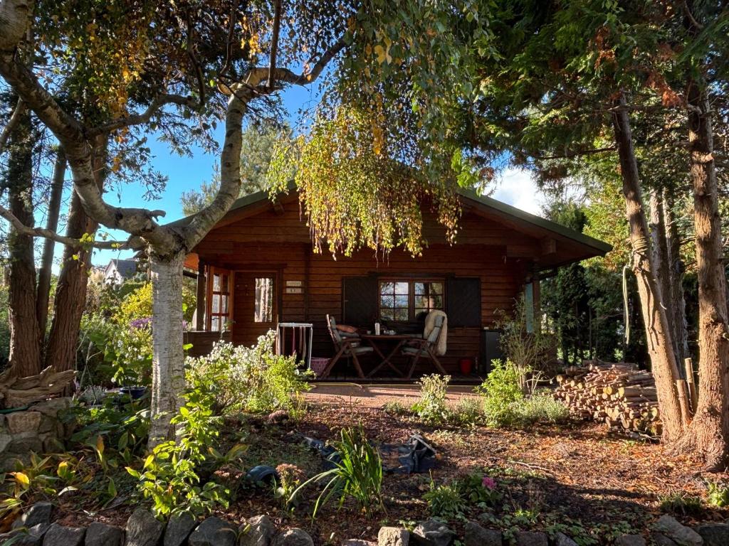 a log cabin with a table and chairs in the yard at Haus Tausendschön in Torgelow
