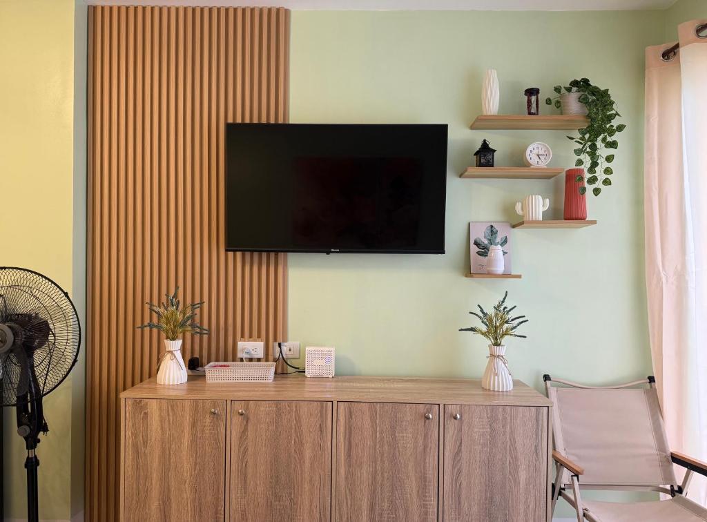 a living room with a television on a wall at D Avenue Studio in Iloilo City