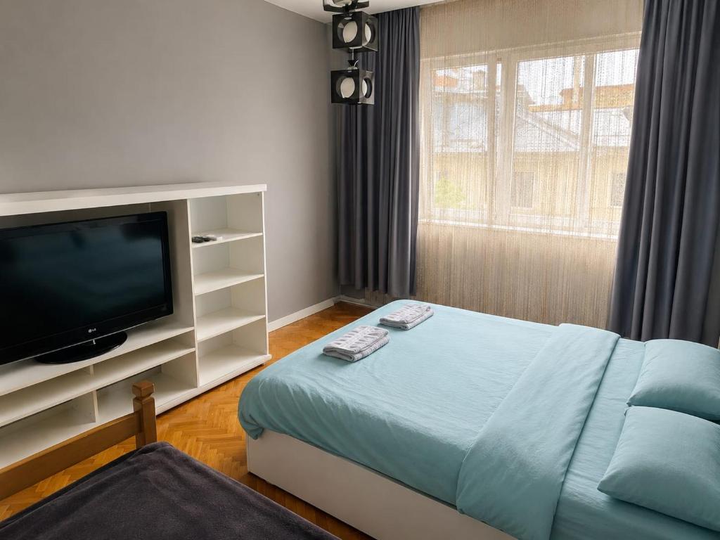 a bedroom with a bed and a tv and a window at Ars Rooms in Prizren