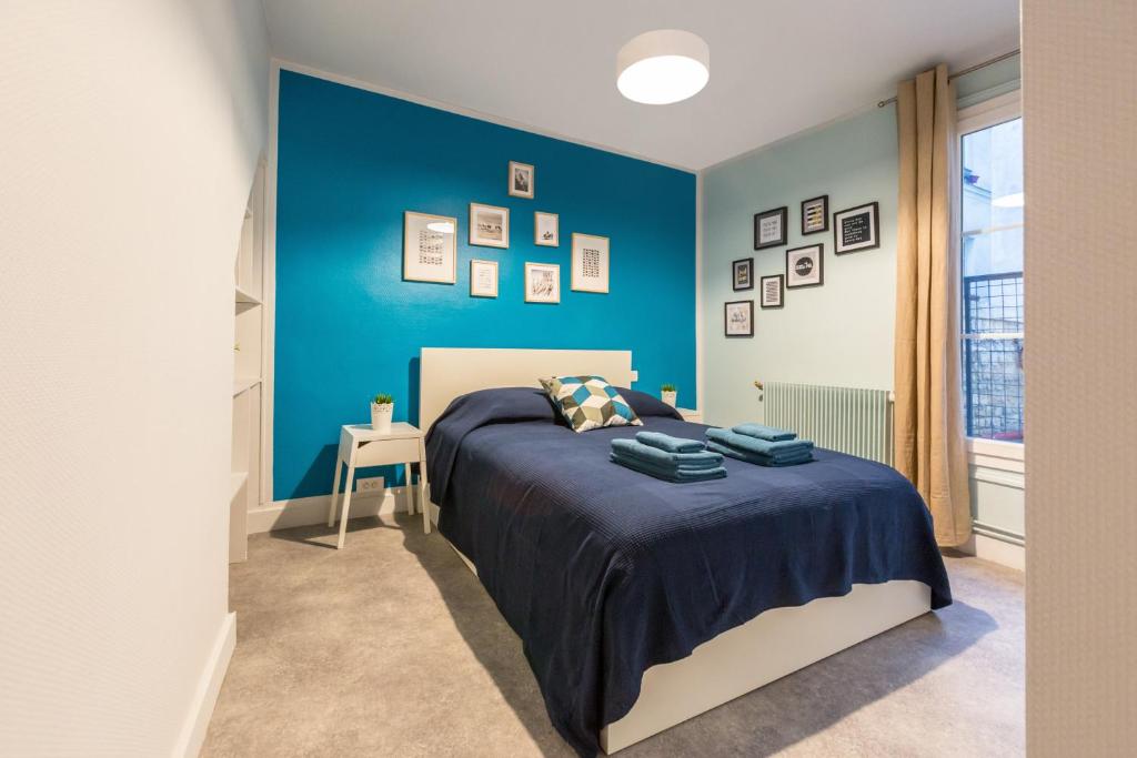 パリにあるアパートメンツ WS ムフタール パンテオンの青いアクセントの壁のベッドルーム1室、ベッド1台が備わります。