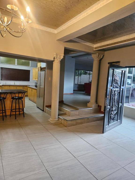 a kitchen and dining room with columns and a table at NAMOLEKA House- Bloemfontein in Bloemfontein