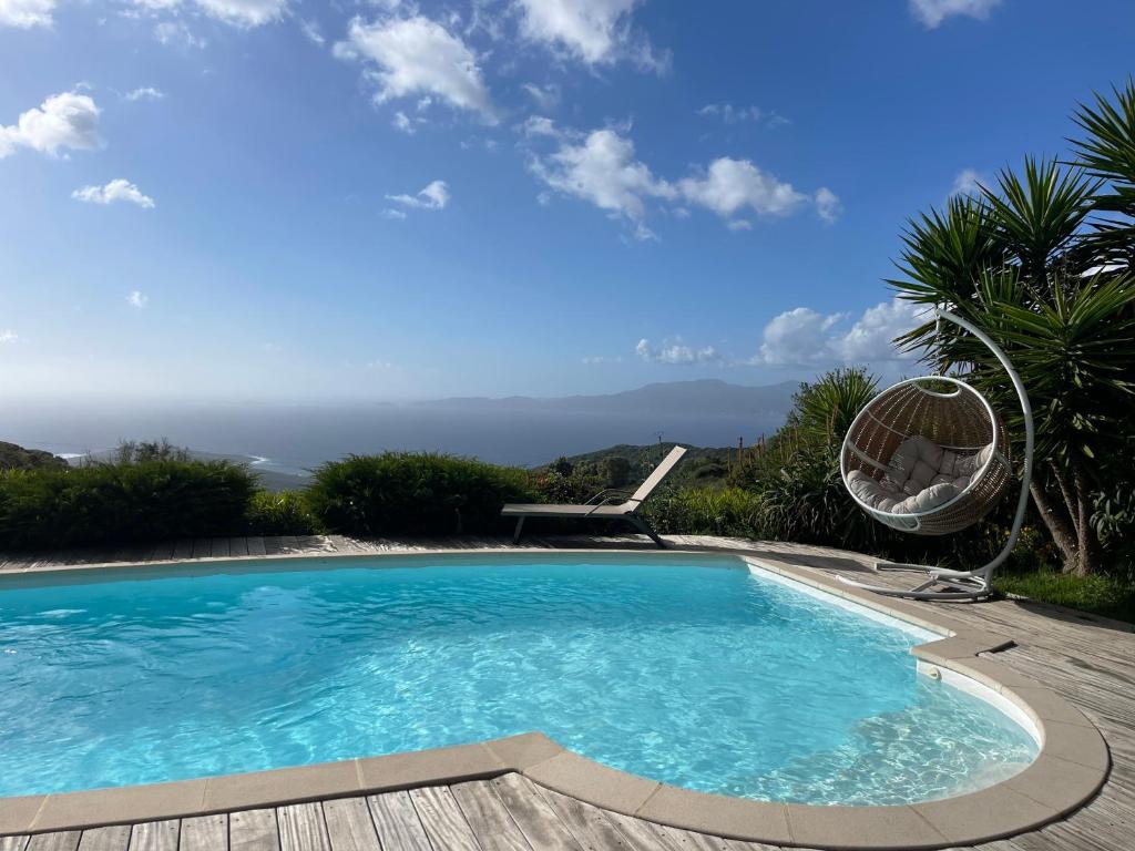 a swimming pool with a view of the ocean at Charmante Maison Vue mer Panoramique à Coti-Chiavari in Coti-Chiavari
