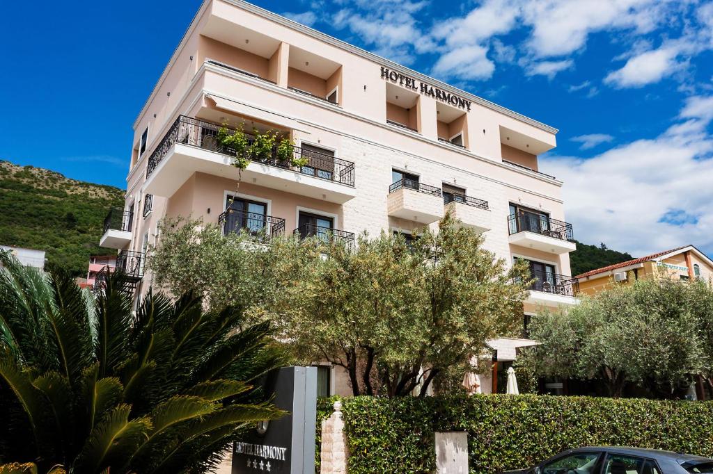 a white building with trees in front of it at Hotel Harmony by Aycon in Petrovac na Moru