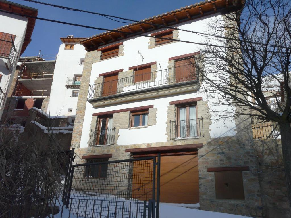 un edificio blanco con una valla delante en Apartamentos El Pajar Alcala de la Selva en Alcalá de la Selva
