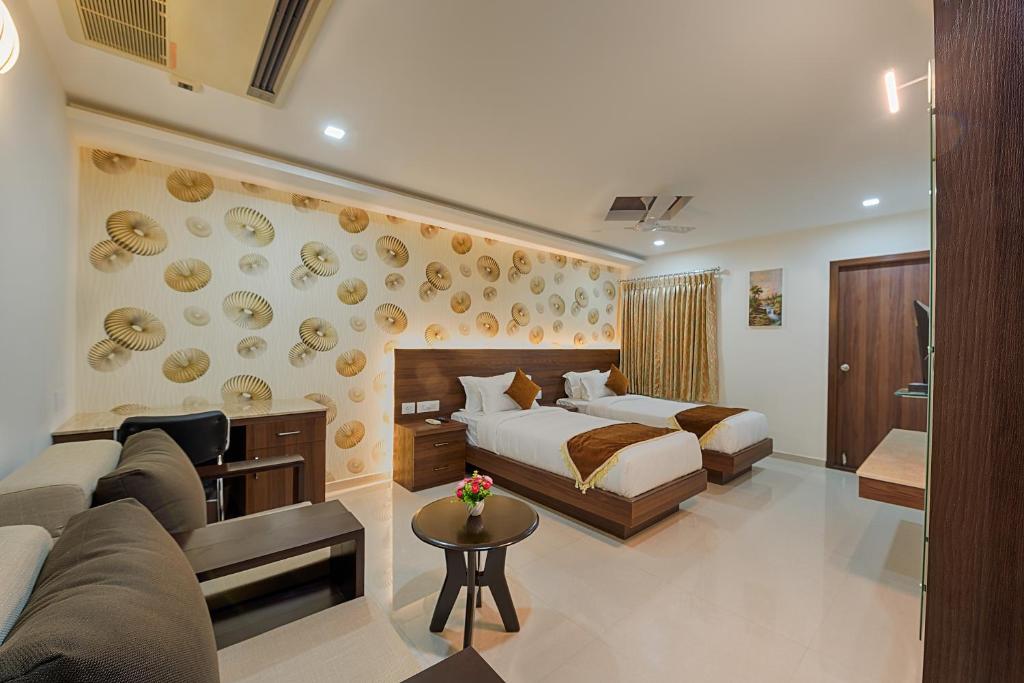 um quarto de hotel com uma cama e um sofá em Holiday Residency Coimbatore em Coimbatore