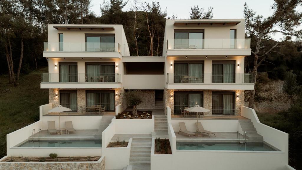 a house with a swimming pool in front of it at Aktis Seaside Living in Iraklitsa