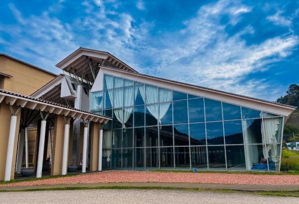 a large building with glass windows on the side at Nature Resort in Kawamoto in Kawamoto