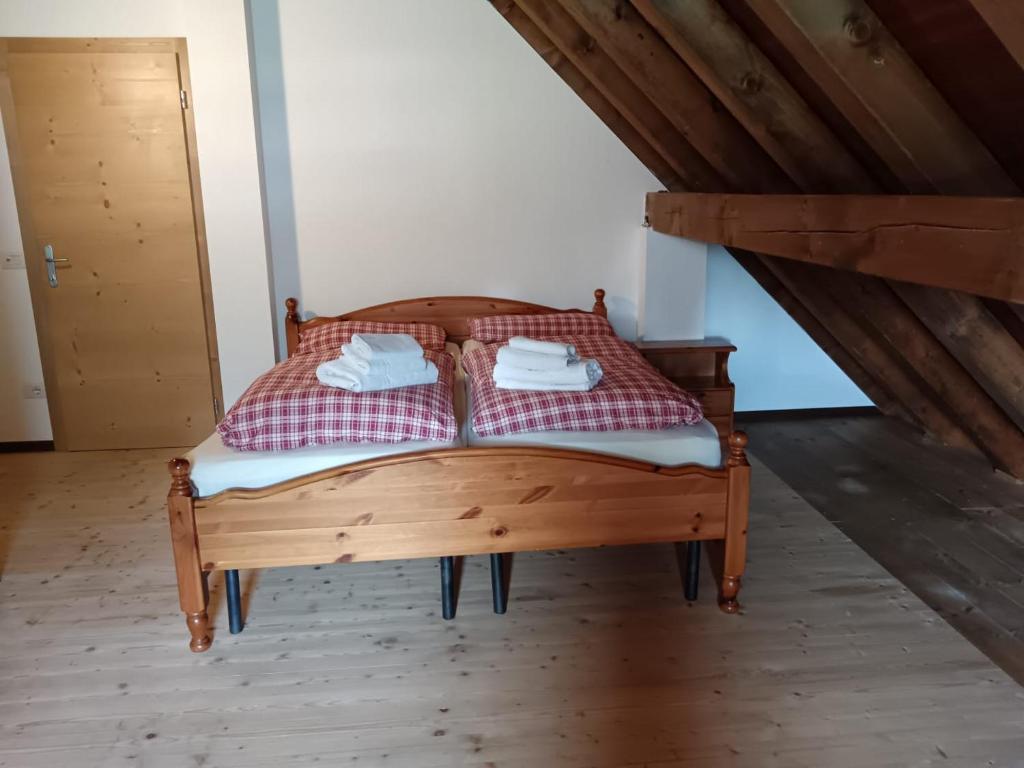 a bedroom with a wooden bed in a attic at Stanza Malga Ciauta in Villanova