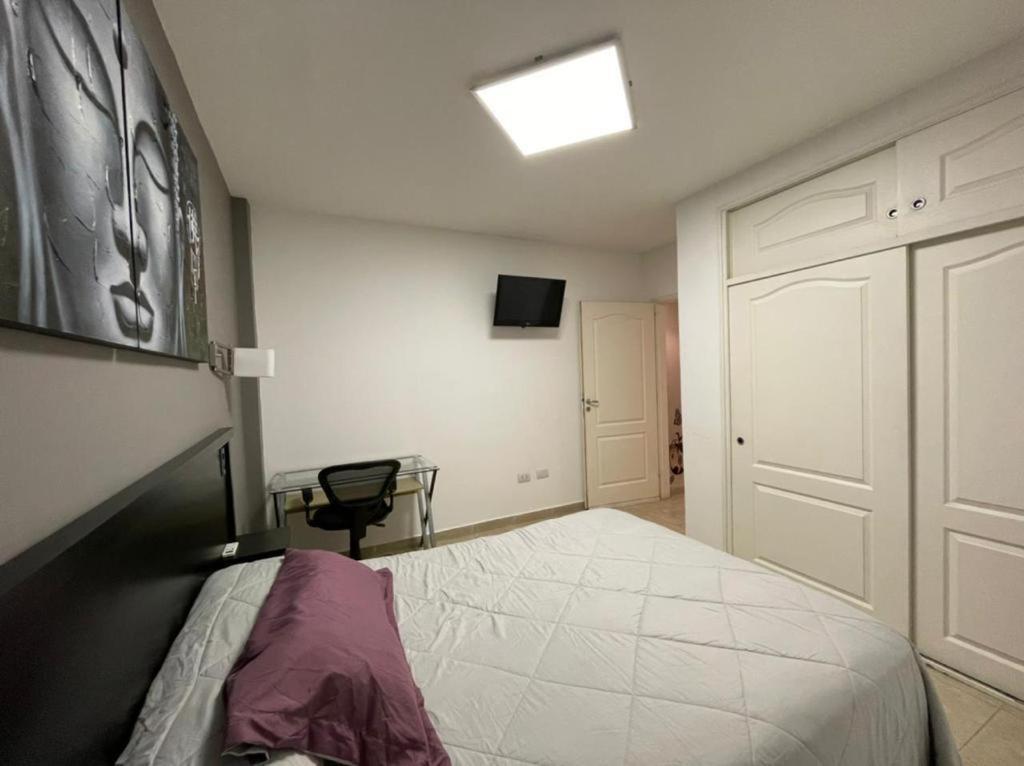 a bedroom with a bed and a table and a window at Nova IVE Apart in San Luis