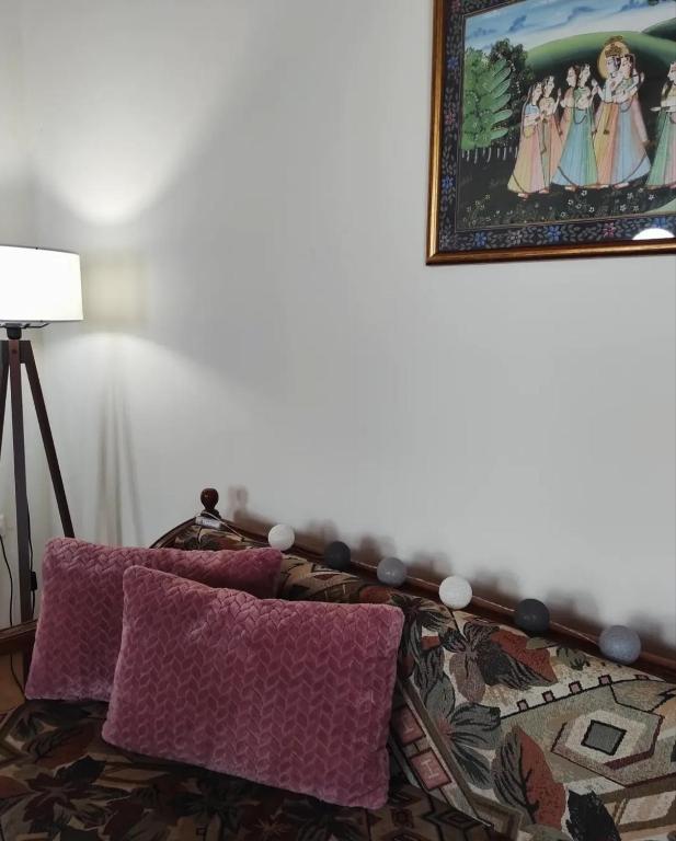 a bed with purple pillows and a picture on the wall at Zarakas home in Monemvasia