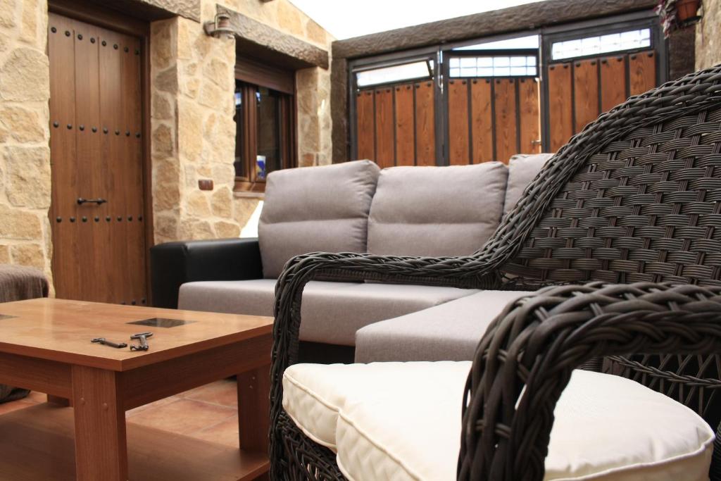 a patio with wicker chairs and a table at El Teñao in Navamorisca