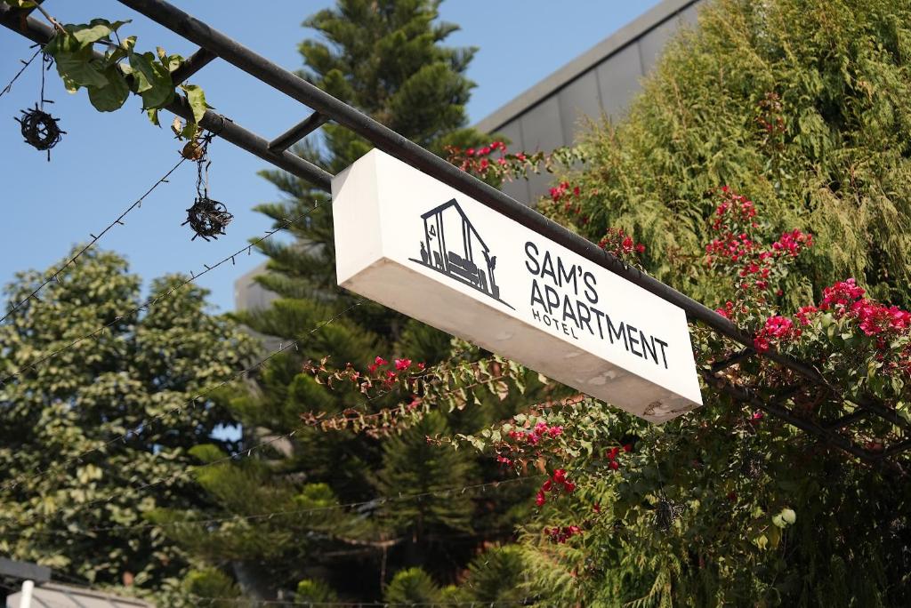 a street sign for santa ana apartments on a pole at Sam's Apartment in Pātan