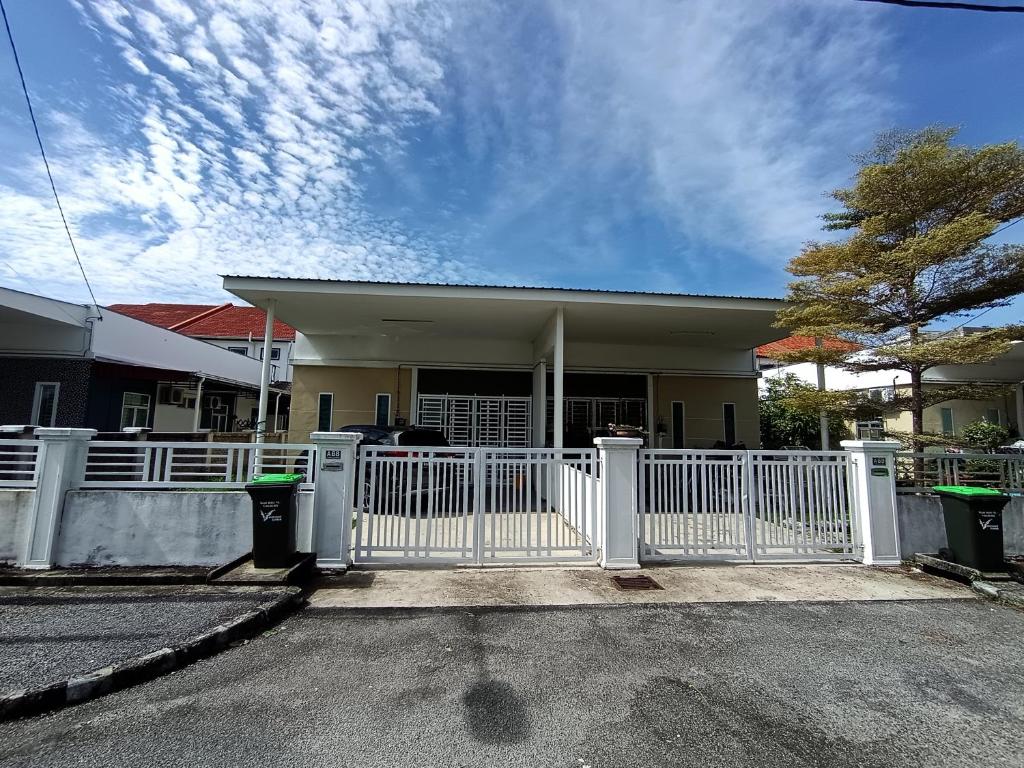 a house with a white fence in front of it at Lynn Homestay Alor Setar in Alor Setar