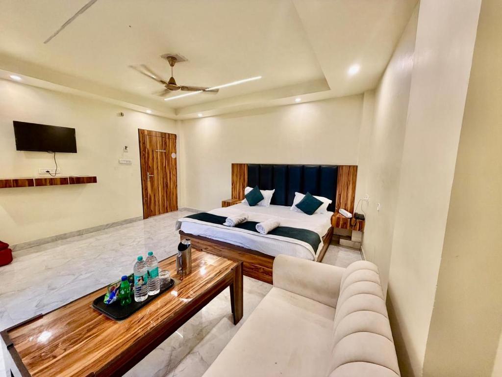 a room with a bed and a couch and a table at Shree Krishna Palace Hotel - Couple Friendly in Lucknow