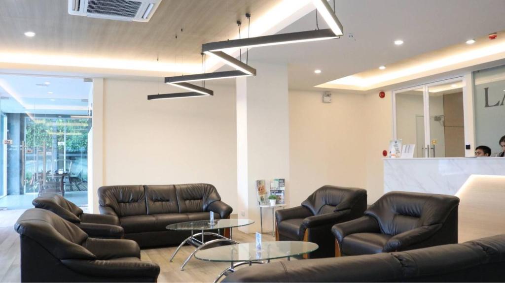 a waiting room with leather chairs and a table at Lampang Residence in Lampang