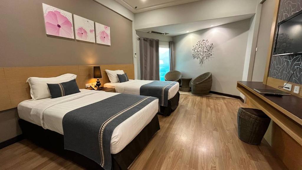 a hotel room with two beds and a window at Langkawi Seaview Hotel in Kuah