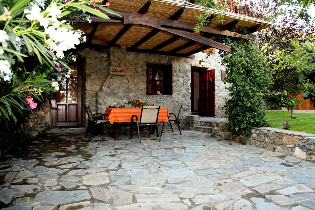 Agia ParaskeviにあるEmilio's Houseのパティオ(パーゴラの下にテーブルと椅子付)