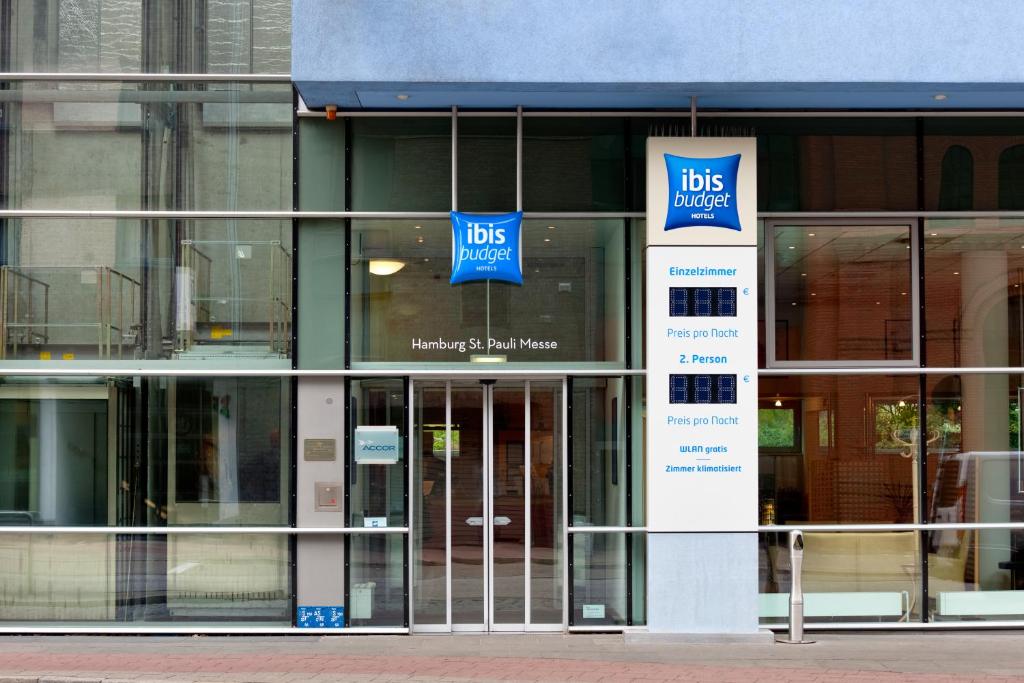 a building with glass doors and signs on it at ibis budget Hamburg St Pauli Messe in Hamburg