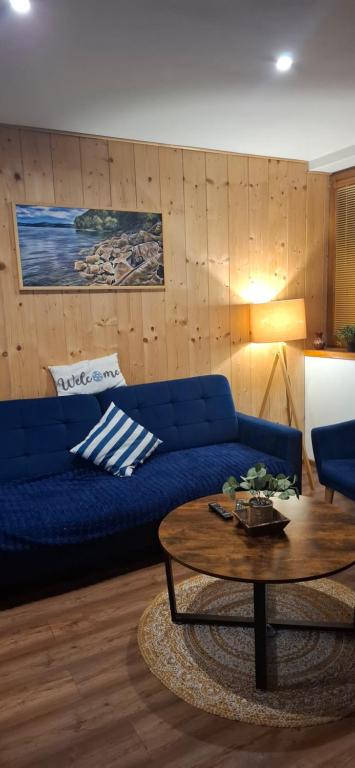 a living room with a blue couch and a table at Apartmany Milano s výrivkou a terasou in Kvakovce