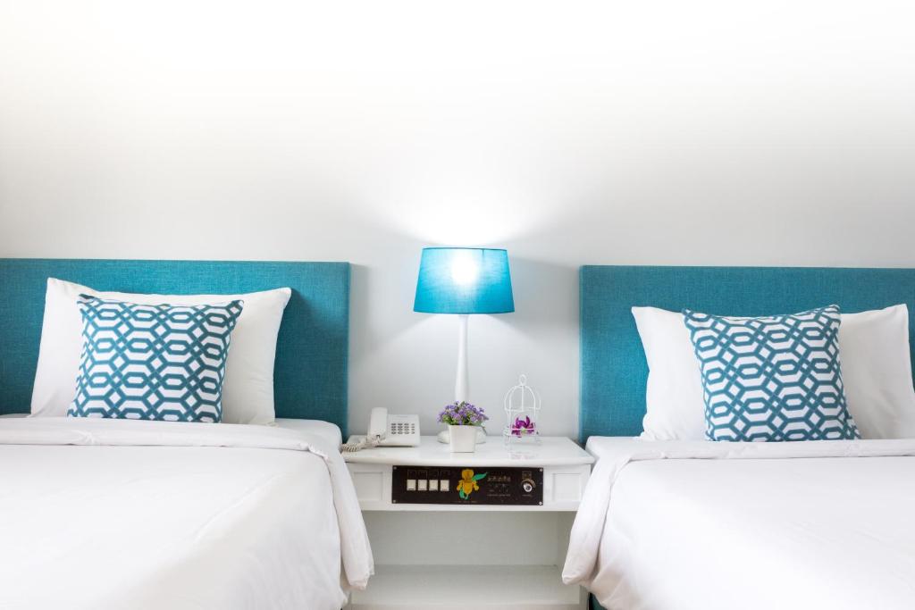 a bedroom with two beds and a blue headboard at Krabi Royal Hotel in Krabi town