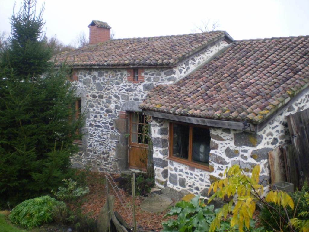 ein altes Steinhaus mit braunem Dach in der Unterkunft Peach Cottage in La Forêt-sur-Sèvre