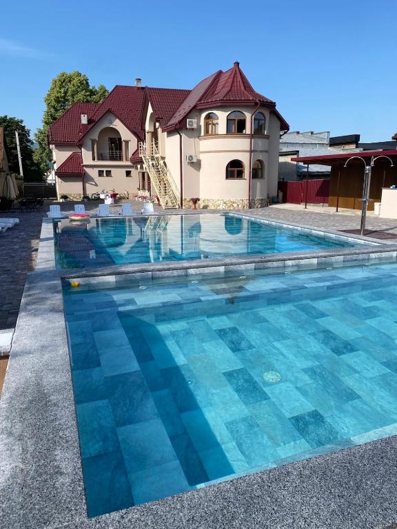 a swimming pool in front of a house at Готель Соняшник in Solotvyno
