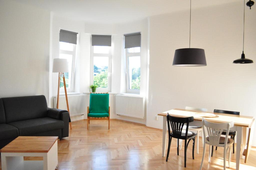 プラハにあるCentral-Modern-Apartmentのリビングルーム(ソファ、テーブル、椅子付)