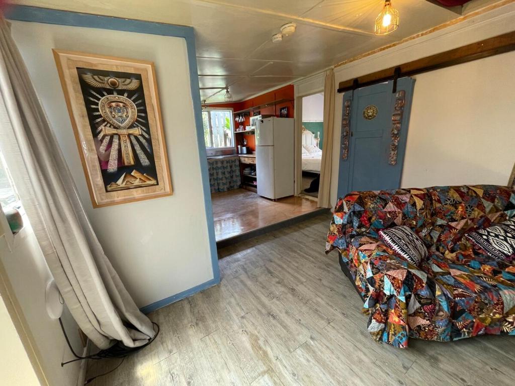 a living room with a couch and a kitchen at Le Bach - Rustic Central Raglan in Raglan