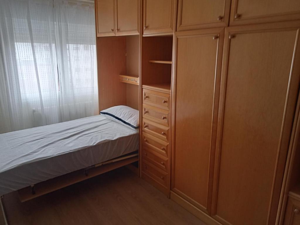 a small bedroom with a bed and a closet at Donato in Gijón