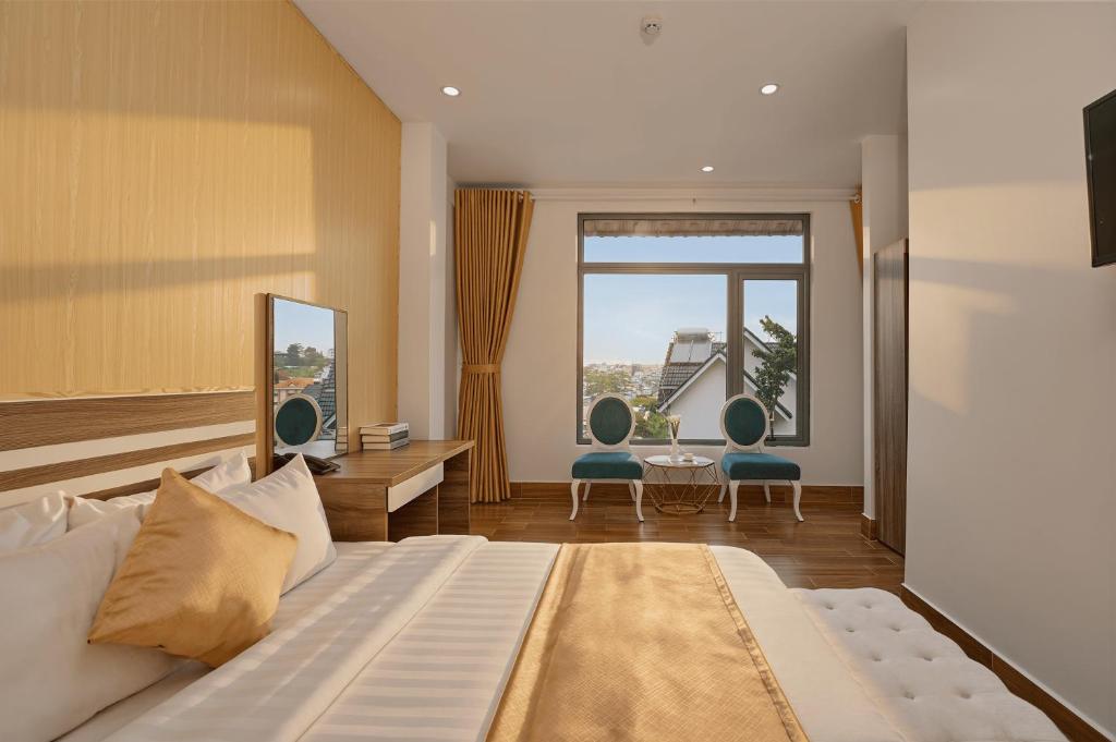 a hotel room with a bed and a large window at Luxury Hotel Dalat in Xuan An