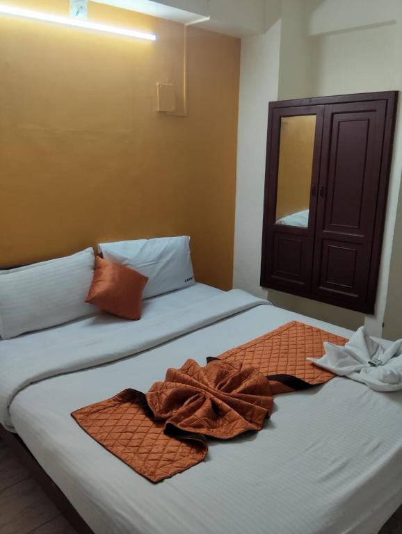 two beds in a room with towels on them at R K Residency Formerly Gamas in Trivandrum