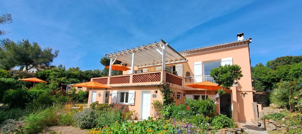 a house with orange umbrellas in a garden at L'Alizé du Levant in Île du Levant
