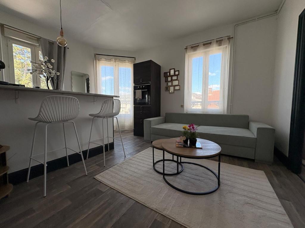 a living room with a couch and a table at Le Balcon in Montargis