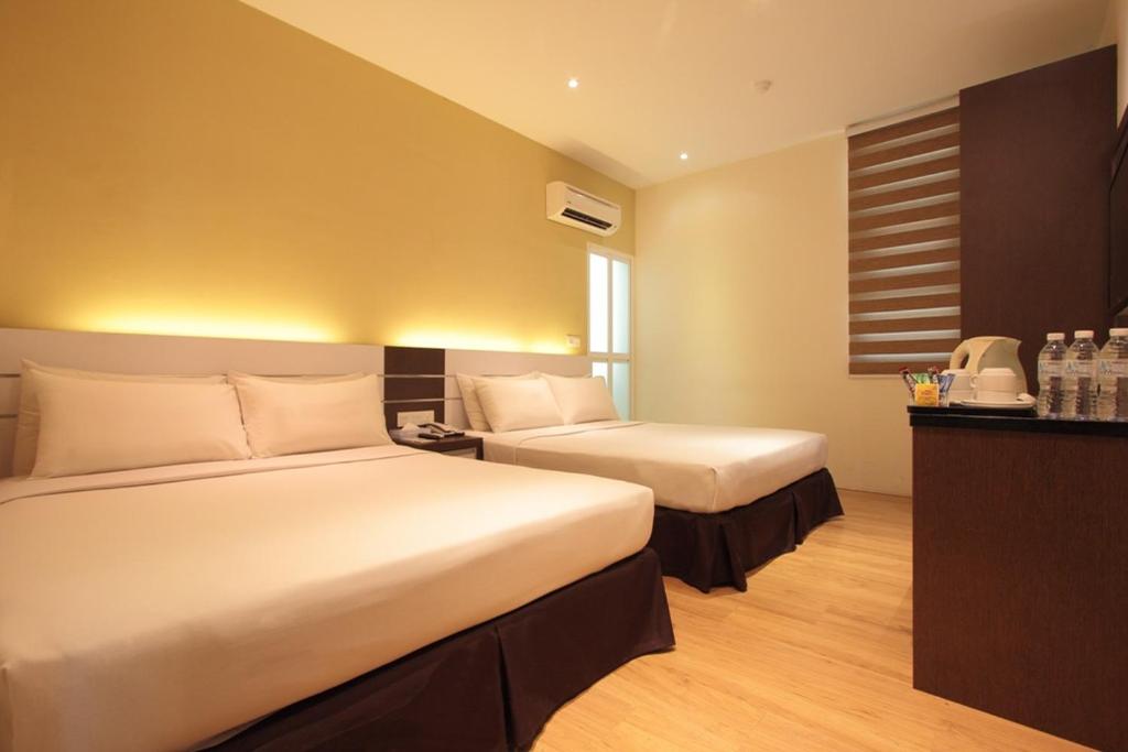 a hotel room with two beds and a telephone at The V Hotel in Kuantan