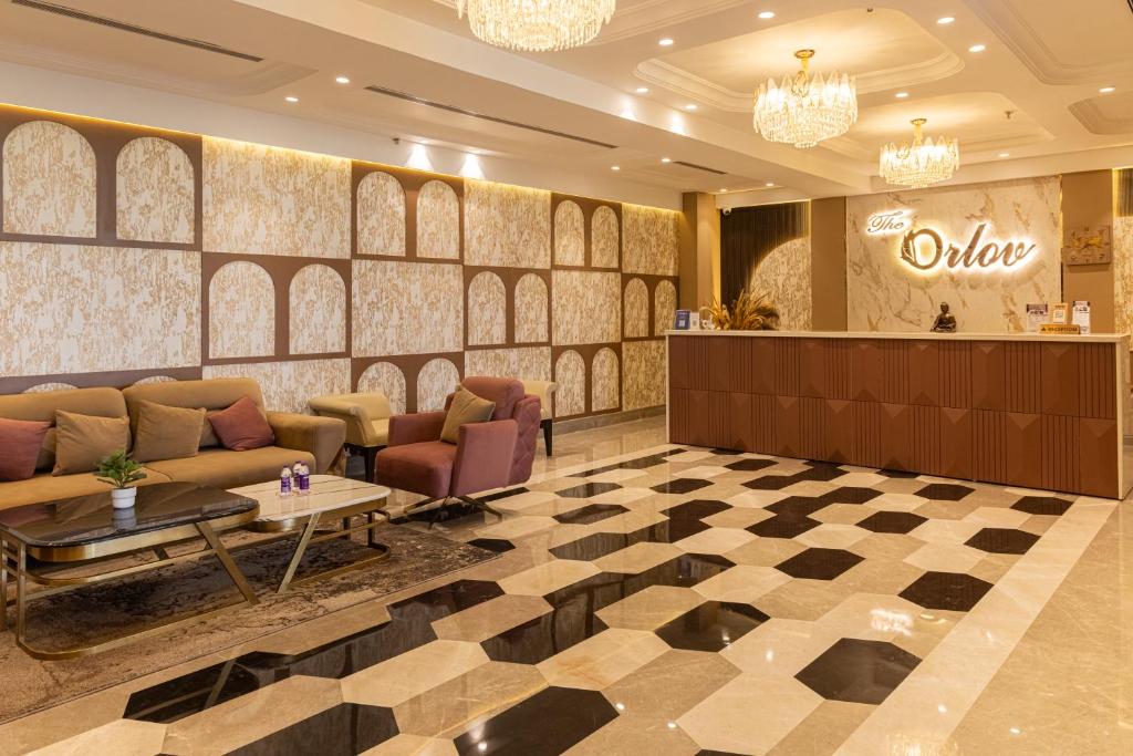 a lobby with a couch and a table and a counter at The Orlov in Babarpur